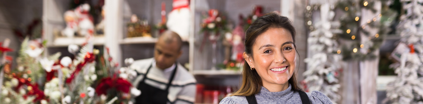 Two people preparing decorations in their festive shop